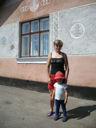 Nadja och sonen Oleg utanför huset.